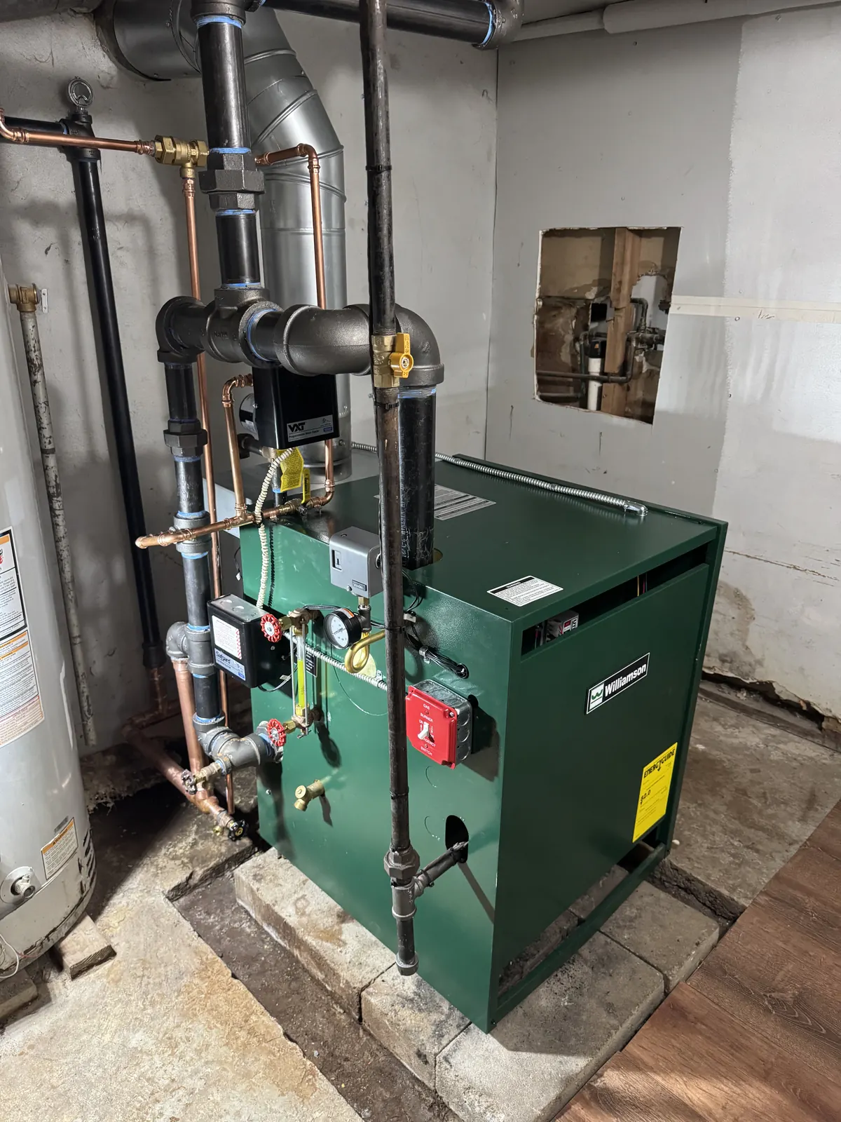 Newly installed basement boiler with copper piping, circulators and flue venting