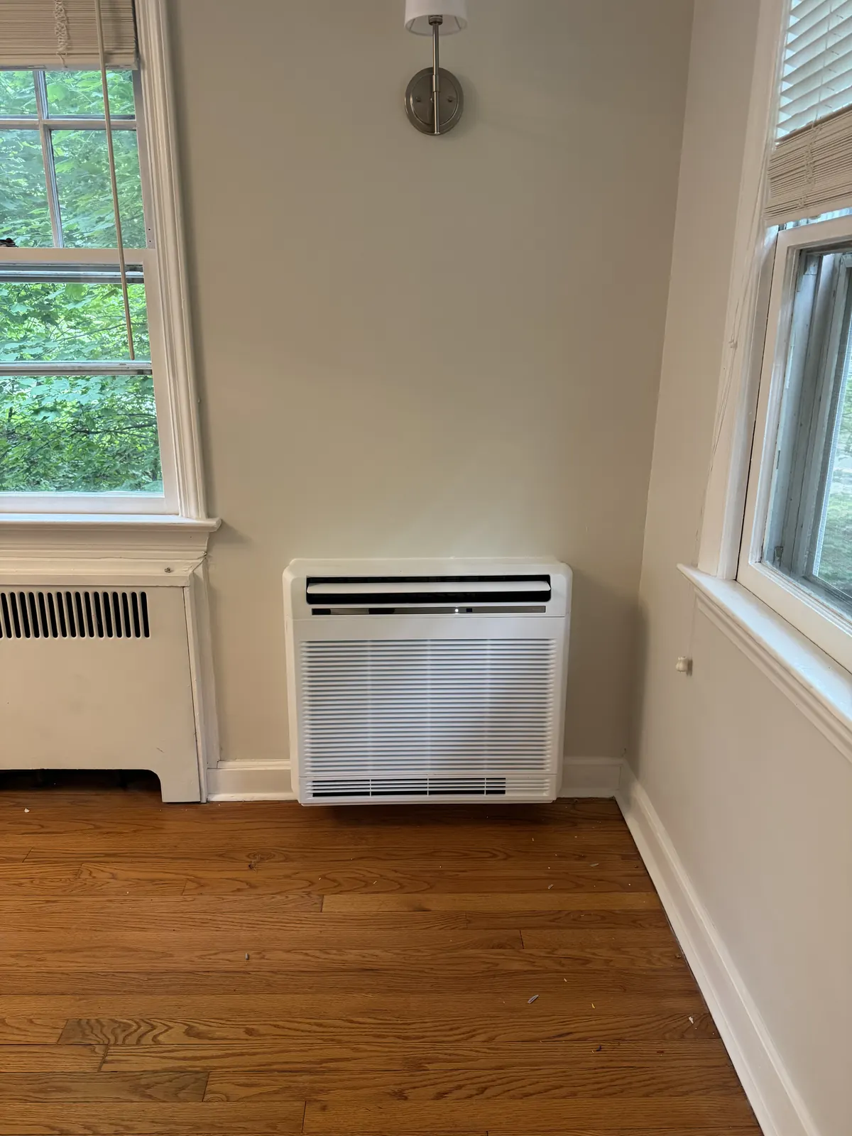 Ductless mini-split indoor unit mounted low on an interior wall in a finished room